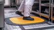 © suyu - Food service worker tripping on floor mat in commercial kitchen, highlighting workplace safety risks, hazard awareness, and accident prevention for reducing injuries in professional environments