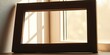 © sasiprapa - Empty wooden frame on windowsill bathed in sunlight