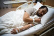 © SAHARAT - A man resting alone in a hospital room, receiving IV Fluids and Medical Care