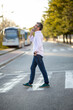 © Paula - Man crossing street while talking on smartphone
