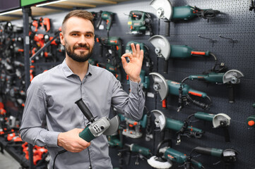 Wall Mural - a buyer in a hardware store walks between with a power tool