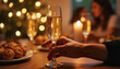 © Ella - Hand holding fluted glass of bubbly drink, festive celebration atmosphere