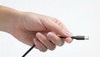 © photostockatinat - Connecting the Future: A close-up shot of a hand delicately holding a USB-C cable, symbolizing technology, connection, and innovation.