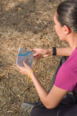 young latin woman reading map and compass during orienteering race. latin young venezuelan