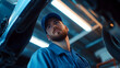 © addison - Car mechanic worker wearing a blue uniform and a cap standing under the car in a modern garage room and repairing or fixing automobile vehicle parts Technician serv