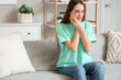 © Pixel-Shot - Young woman suffering from toothache on sofa at home