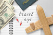 © Pixel-Shot - Notebook with text TRAVEL TIPS, wooden airplane and money on light background, closeup. Itinerary concept