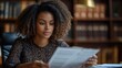 © siyons - Woman reviewing documents in a library setting