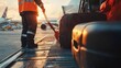 © NAIMAH - Sunset at the Airport: Baggage Handler Loading Luggage onto Airplane