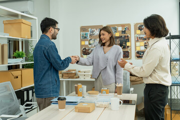 Sticker - Business team handshake after successful eco-friendly product design collaboration in creative workspace