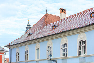 A blue building with a red roof and a clock tower