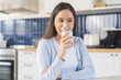 © KMPZZZ - Health care asian young woman, girl holding a glass of white fresh, dairy soy milk to drink for calcium, vitamin wholesome good nutrition in the morning at kitchen home, product of healthy people.