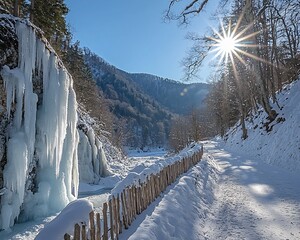 Sticker - Sunlit winter scene with icy waterfall, snow-covered path, and wooden fence.