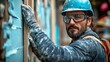 © Atchariya63 - A skilled worker in a hard hat and safety goggles inspects a construction project.