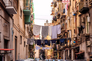 city view of old down town street of slum area with vintage facades of buildings and drying clothes above old urban street