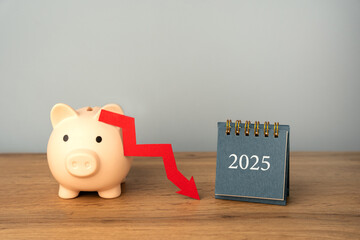 Piggy bank with a downward arrow and a 2025 calendar. Economic crisis and recession. Bankruptcy and financial crisis. Analysis and analytics. Capital outflow. GDP. Forecasting.