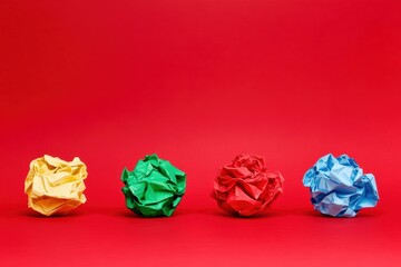 Poster - Colorful crumpled paper balls on a vibrant red background, ideal for creative and artistic projects. Unique and engaging.