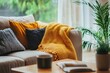 © Ibnu - Cozy living room with beige sofa, yellow blanket, and pillows.