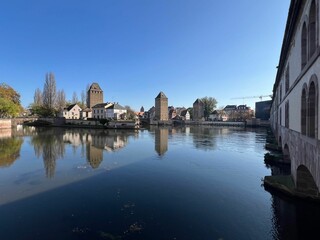 Poster - Strasbourg's historic riverside architecture under blue skies.