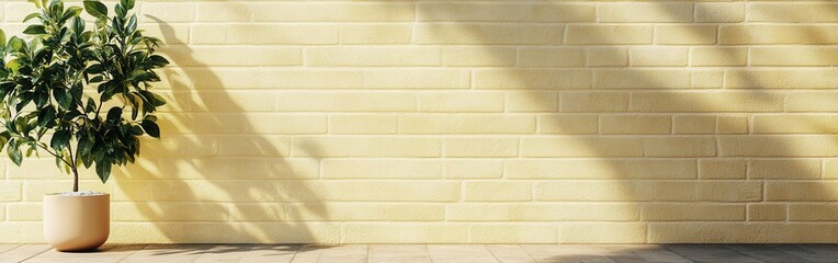Poster - Smooth pale yellow brick wall complemented by a small green plant in a white pot