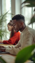 Poster - Young man focused on work in a cozy indoor setting surrounded by plants and natural light