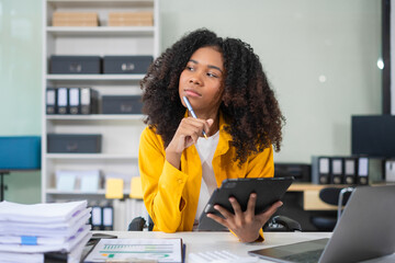 Wall Mural - Portrait of a young businesswoman thinking work concept sitting at desk in the office.