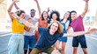 © Davide Angelini - Multicultural young people smiling at camera together outside - Happy group of friends having fun walking on city street - Youth community concept