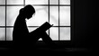 © Cloudyew - Silhouette of a Woman Reading a Book by a Large Window with Soft Natural Light