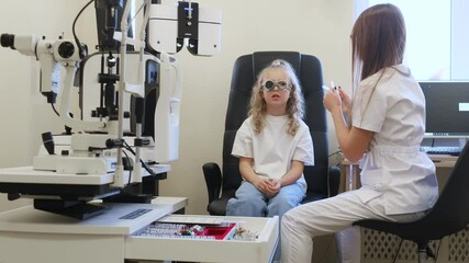 Wall Mural - Professional equipment. Little girl at the ophthalmologist clinic with doctor.