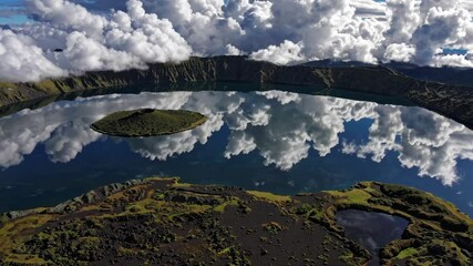 Aufkleber - Stunning aerial view of clouds reflecting on calm lake surrounded by lush greenery in a serene mountain landscape