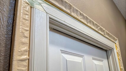 Fototapete - A detail view of a door frame integrated with drywall the tape along the edges perfectly feathered and blended into the surrounding wall surface illustrating the care taken in