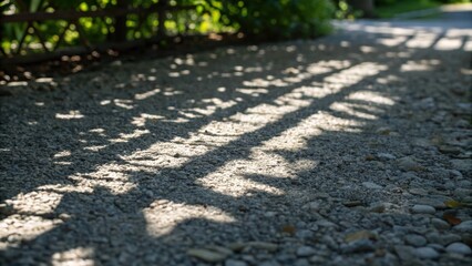Aufkleber - An artistic closeup focusing on the shadows cast by the gravel as sunlight filters through nearby foliage. The interplay of light creates an abstract pattern on the gravel surface