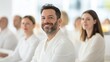 © mirifadapt - Smiling people men and women in white medical suits attending workshop, medicine conference