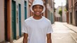 © QuoDesign - Black teenage boy wearing white t-shirt and white bucket hat standing in a city alley