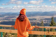 © EdNurg - Young woman wearing orange enjoying mountain landscape from viewpoint