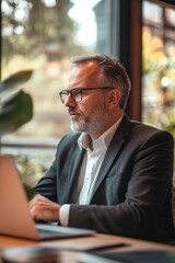 Poster - a man in a suit is sitting at a table with a laptop in front of him
