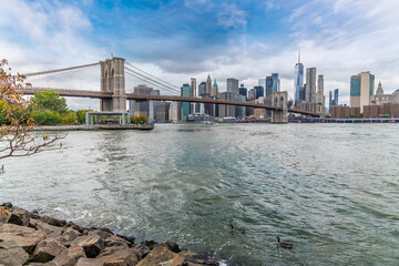 Wall Mural - A view across the East river towards the Brooklyn bridge and Manhattan in New York, in the fall