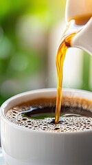 Wall Mural - A cup of coffee being poured into a white cup