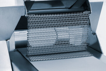 Fototapete - A metal mesh is being used to hold a piece of food. The mesh is silver and has a pattern