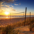© Fazila - Beach Volleyball nets at sunset, ocean, sand, sky, and grass