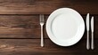 © Bule - Empty Plate with Fork and Knife on Wooden Table