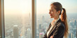 © Radorog. - A businesswoman stands near a panoramic window with a view of the city