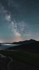 Wall Mural - vertical view of milky way galaxy stars moving over countryside landscape astronomy time lapse