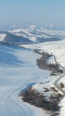 Fototapete - Vertical aerial video from drone of winter road under snow in Altai. Biryuksinsky mountain pass.