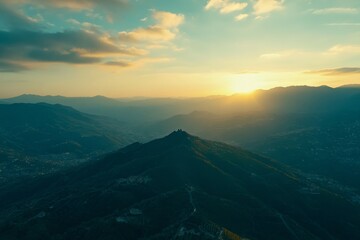 As the sun rises, the Dolomites' distant peaks form a pattern of silhouettes against the orange sky