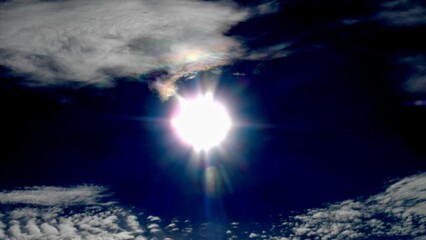 Poster - Dark blue sky, sun rays and colorful, pearl colors on Clouds iridescence, Irisation around sun - abstract sky background. Topics: optical phenomenon, beauty of nature, air space, weather, meteorology