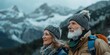 © Oksana - Elderly couple in warm clothing hikes in snowy mountain landscape. Concept of active lifestyle and travel. For travel and outdoor adventure content.