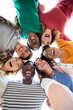 © CarlosBarquero - Vertical. Selfie from below of diverse group friends posing embracing in circle looking excited at camera. Cheerful young people standing hugging outdoor. Portrait of generation z enjoying free time