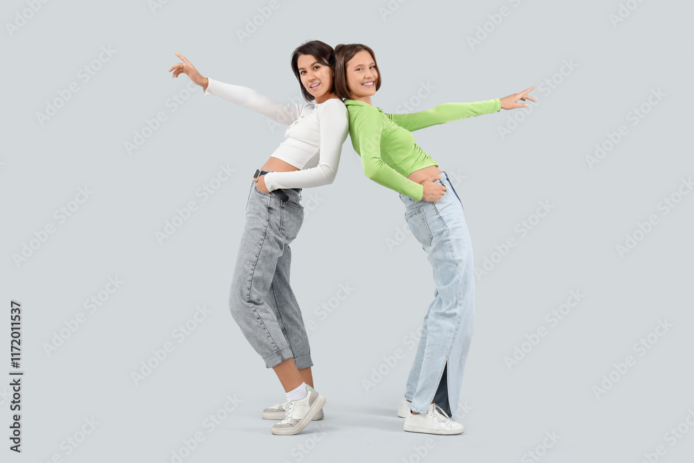 Young women in jeans on light background
