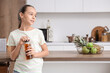 © Pixel-Shot - Teenage girl opening bottle of apple juice in kitchen